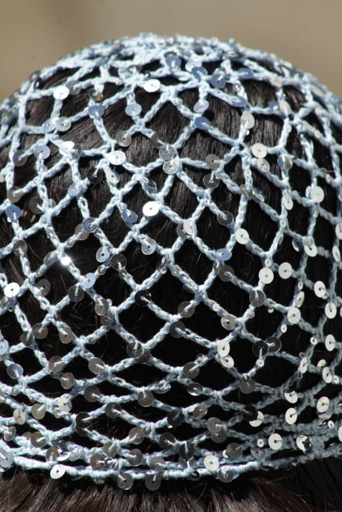 Close-up of a headband with a mesh design and sequins on a blurred background