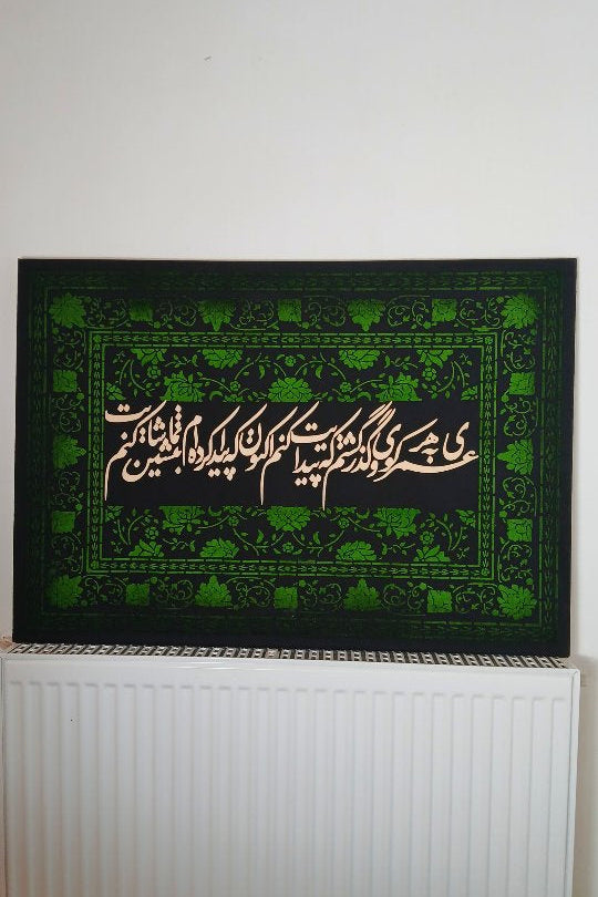 Green and black prayer mat with Arabic text on a white radiator.