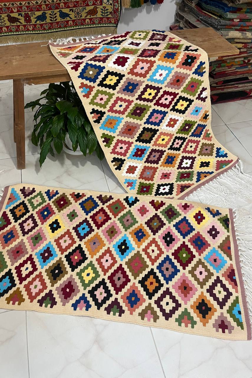 Colorful geometric-patterned rug on a wooden table with a plant underneath.