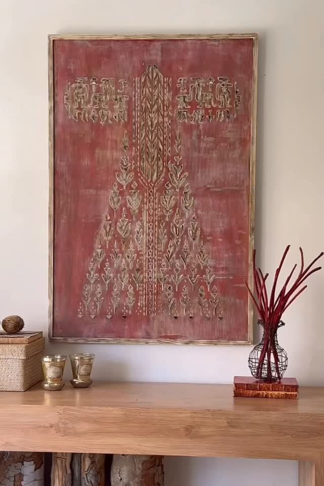 Decorative wall art above a wooden table with decorative items.