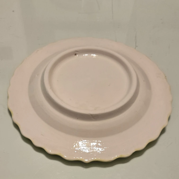 White ceramic plate with scalloped edge on a light gray background