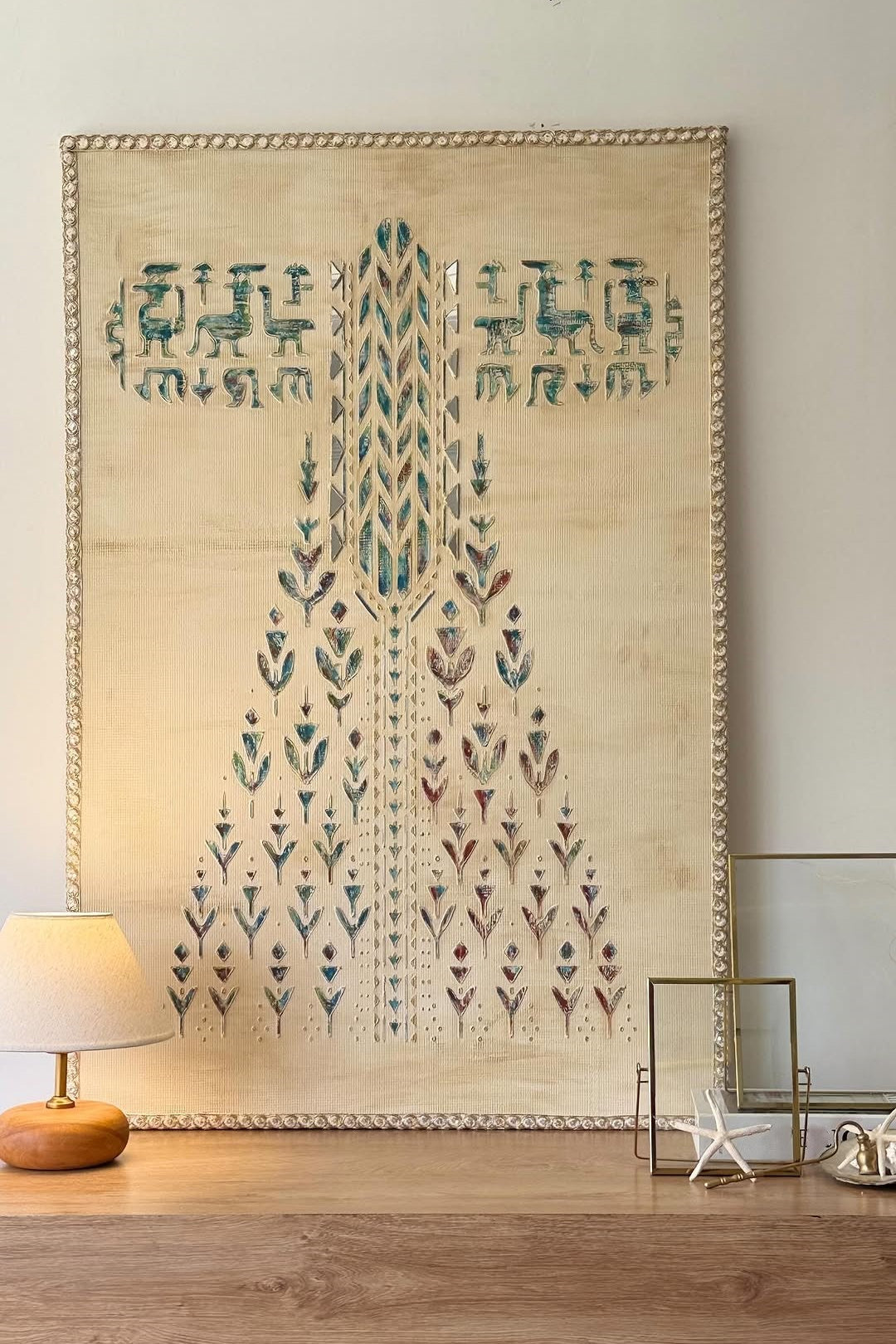 Decorative wall hanging with geometric patterns on a wooden surface.