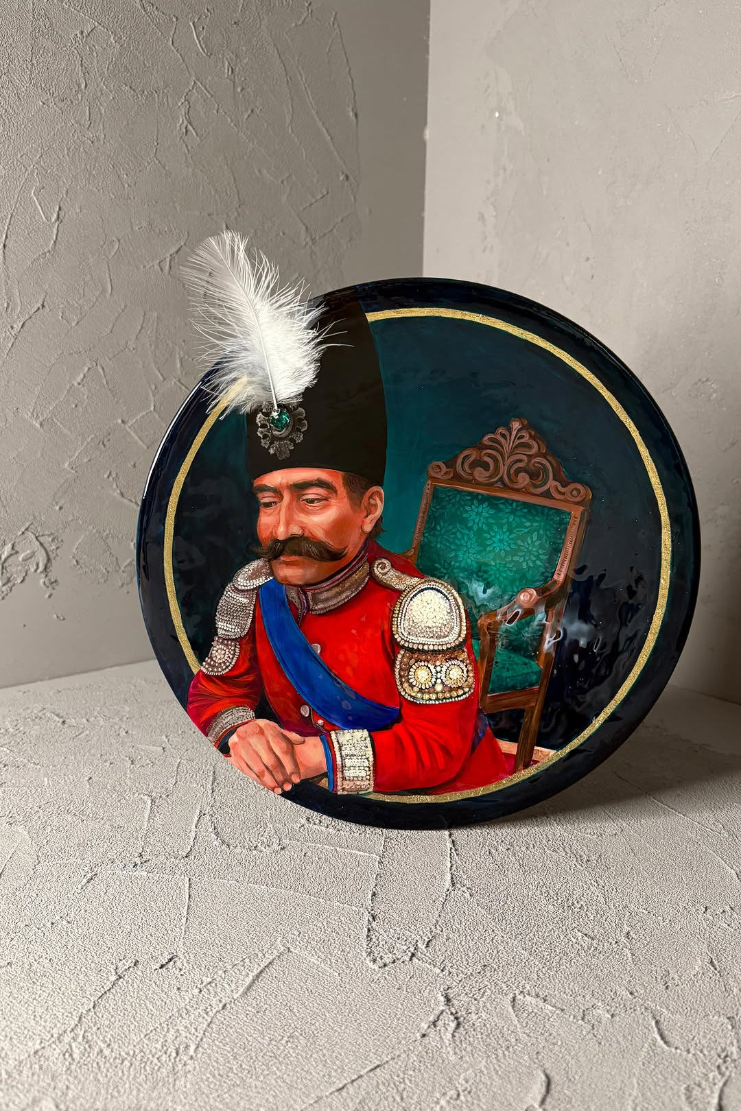 Decorative plate with a painted portrait of a man in military uniform on a textured surface.