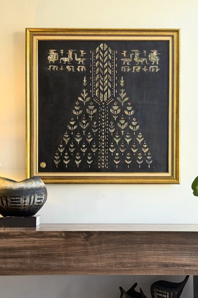 Framed artwork with geometric design on a wall above a wooden shelf.