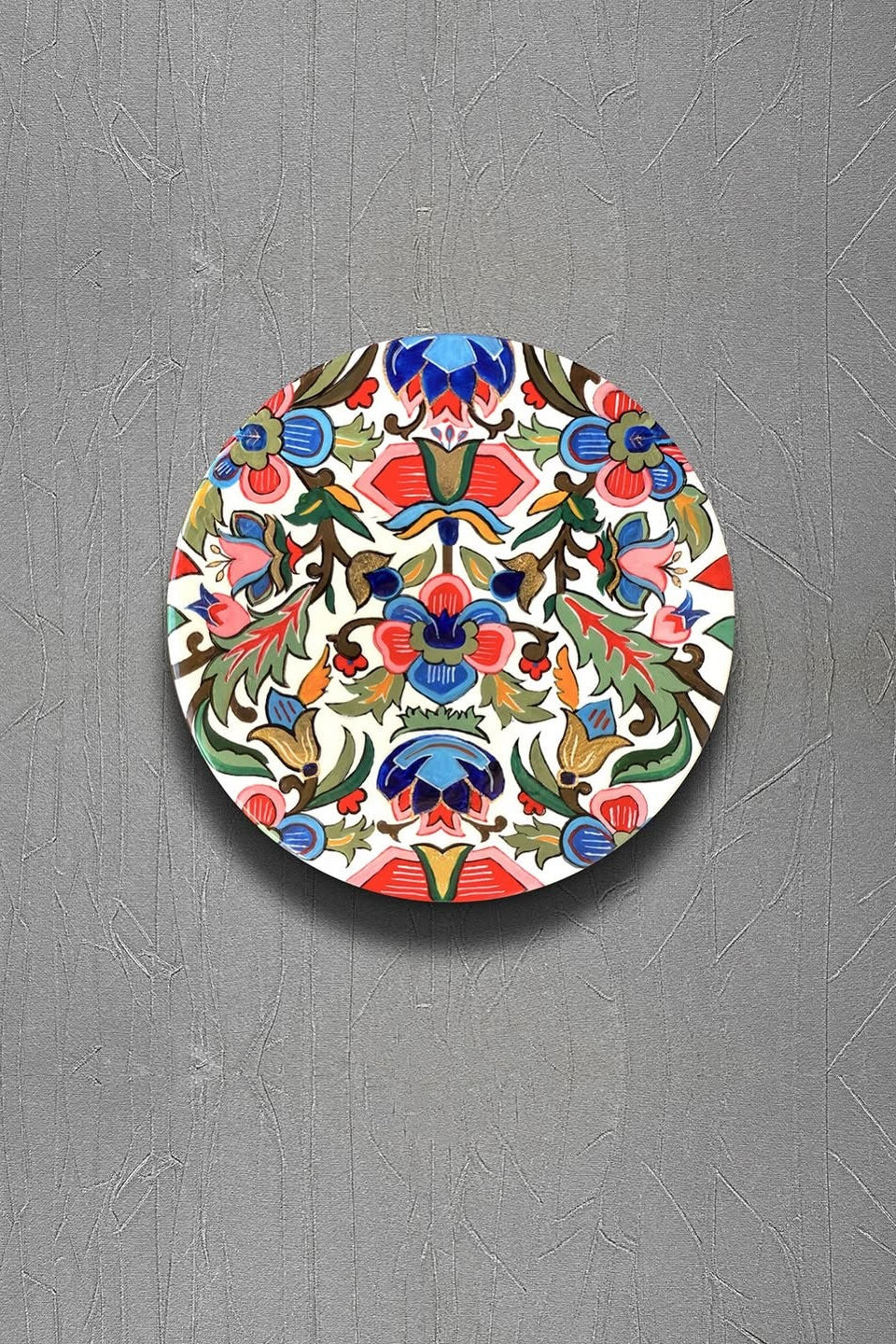 Decorative plate with colorful floral and geometric pattern on a gray background
