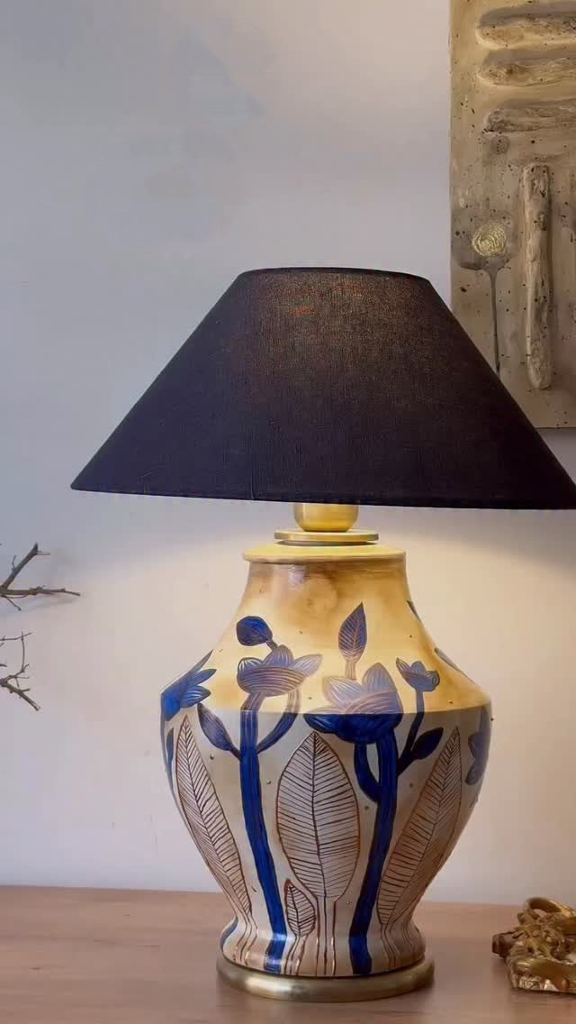 Decorative table lamp with a black shade on a wooden surface.