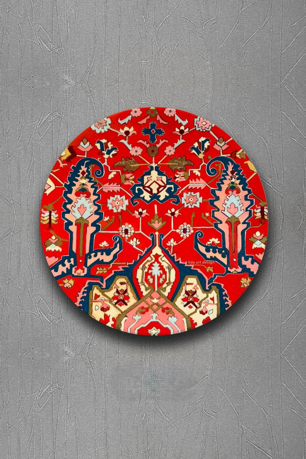 Decorative red circular mat with intricate patterns on a gray background