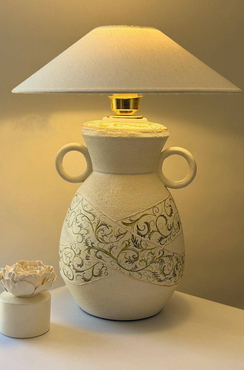 Decorative table lamp with intricate design on a plain background