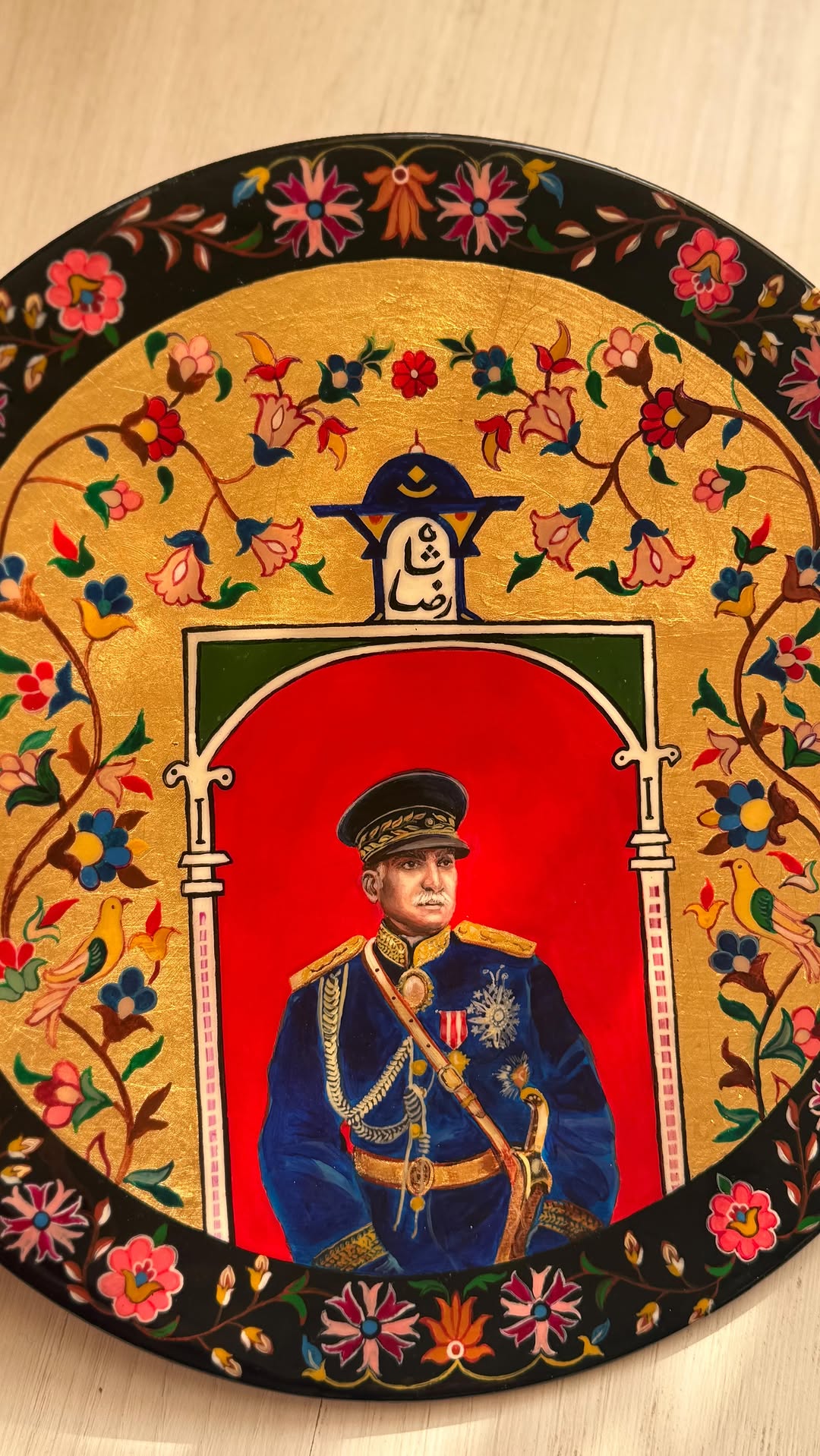 Decorative plate with a portrait of a person in military uniform surrounded by floral designs.