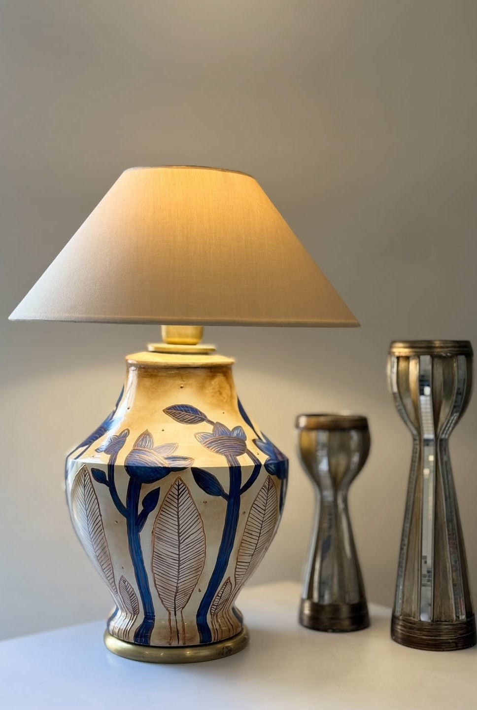 Decorative lamp with a patterned base on a surface against a neutral background
