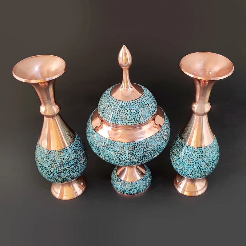 Set of three decorative vases with turquoise and copper design on a dark background