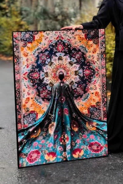 Person holding a large colorful tapestry with a floral design and a silhouette of a person in a flowing dress.
