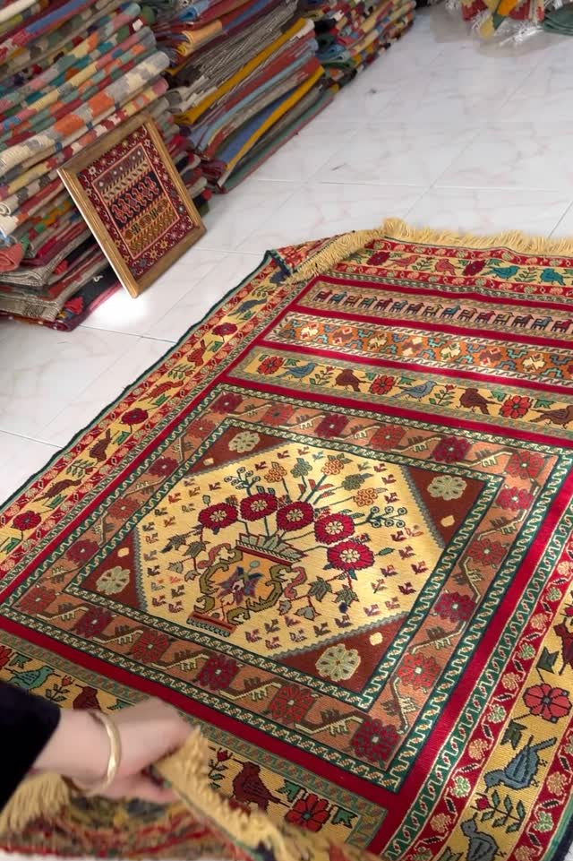 Colorful patterned rug with intricate designs on a white floor.