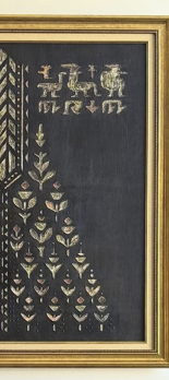 Decorative black fabric with gold embroidery in a gold frame